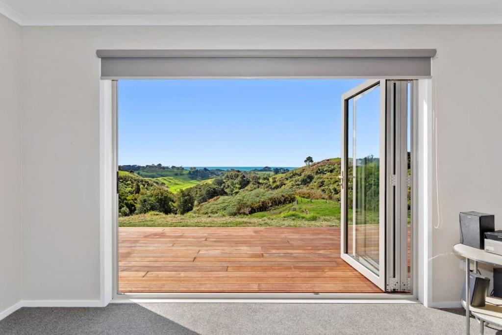 an open sliding glass door with a view of a patio at Coast View Farm Stay in Opotiki