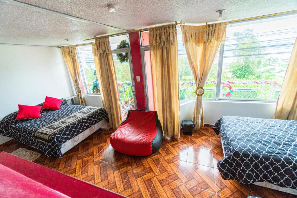 a bedroom with two beds and a window at HOSPEDAJE DON PABLO in Otavalo