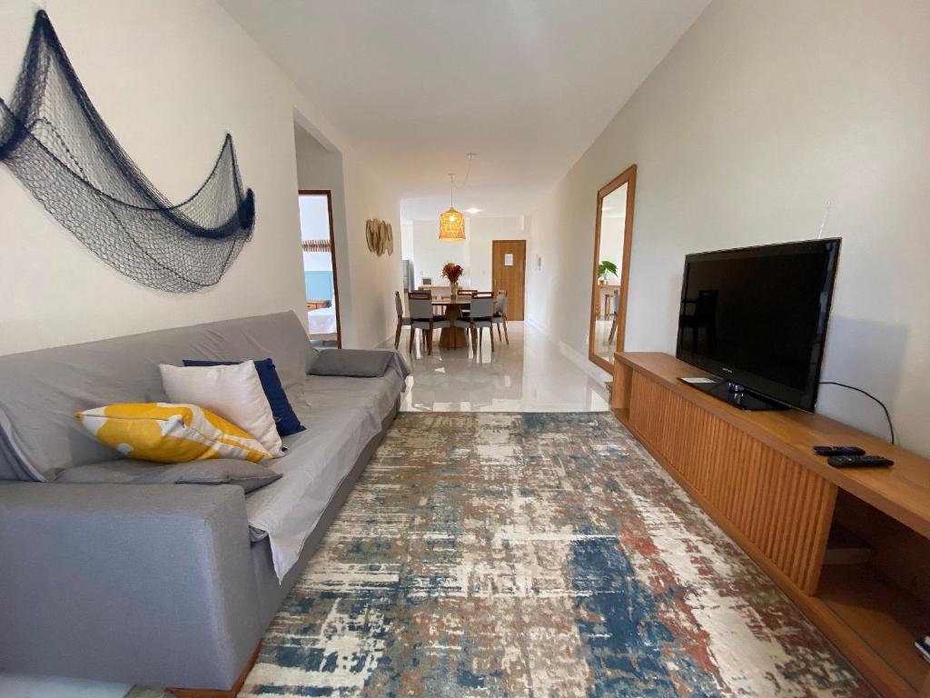 uma sala de estar com um sofá e uma televisão de ecrã plano em Apto de alto padrão 100 m da Praia de Costazul - WIFI 200MB - TV Smart - 2 Quartos - Garagem - Cozinha equipada - Churrasqueira em Rio das Ostras