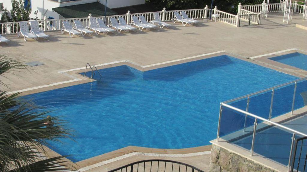 a large pool with chairs and blue water at YALIKAVAK KIZILBURUNDA FIRSAT TATİL EVİ in Bodrum City