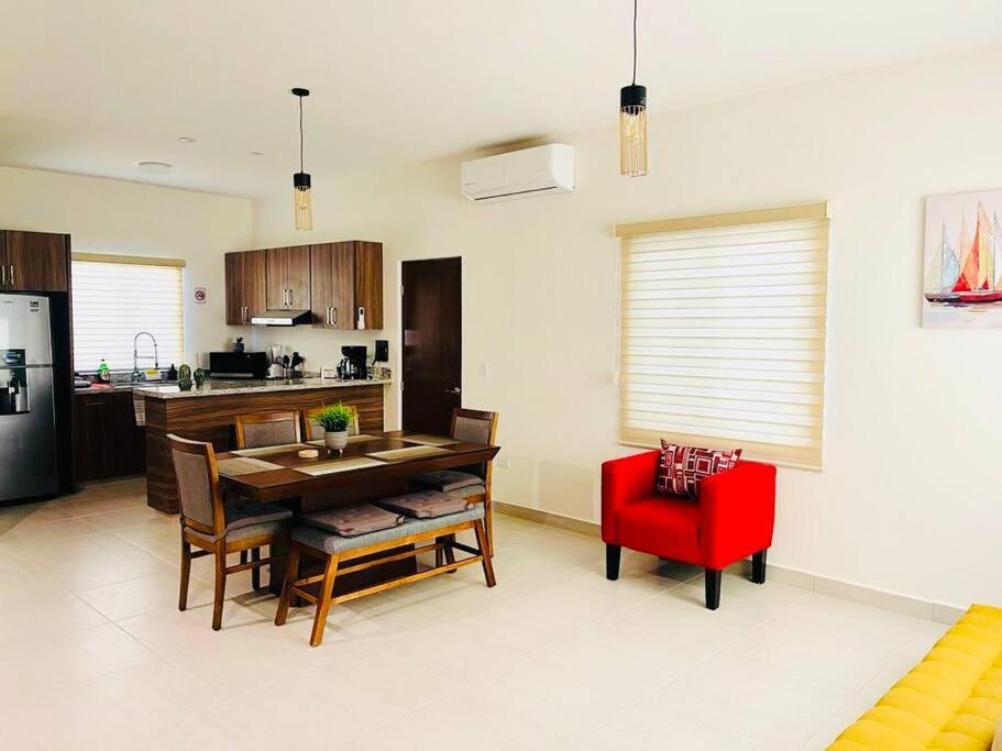 a kitchen and dining room with a table and a red chair at Casa SOL #222, para 6 personas in La Paz