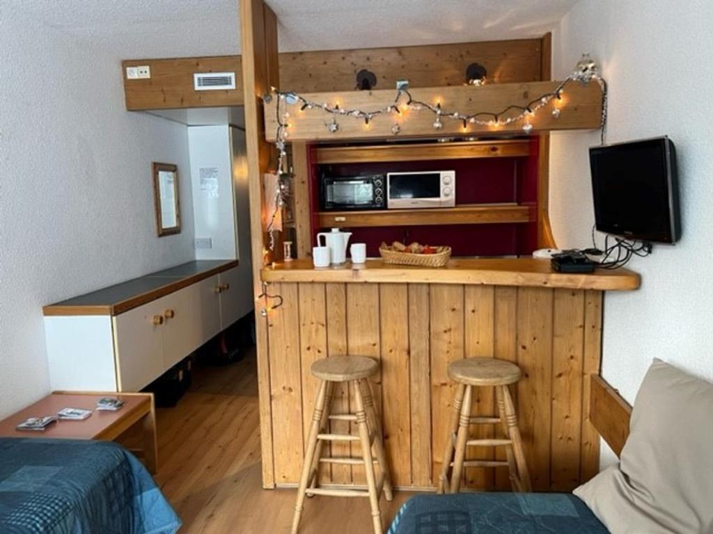 a small kitchen with a bar and stools in a room at Studio Les Arcs 2000, 1 pièce, 4 personnes - FR-1-346-545 in Arc 2000