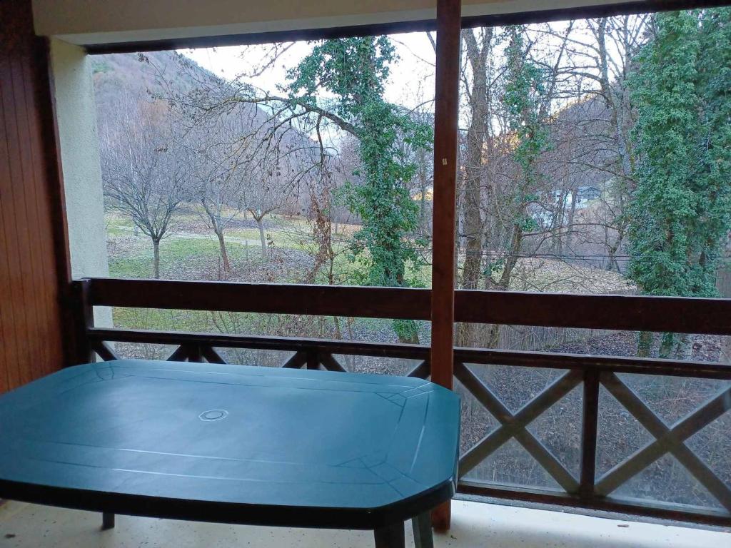 a blue bench in a window with a view of a field at Brides Les Bains : Apt 8 pers, WIFI, Parking - FR-1-512-264 in Brides-les-Bains