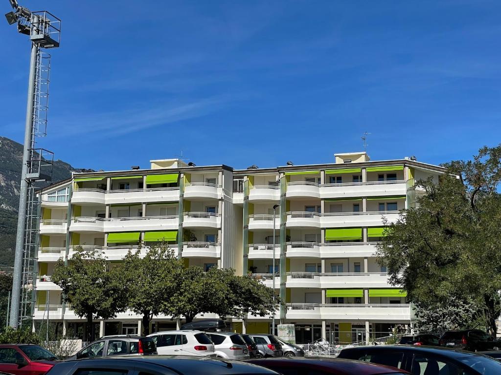 a white apartment building with cars parked in front of it at RESIDENCE BIANCOVERDE in Rovereto