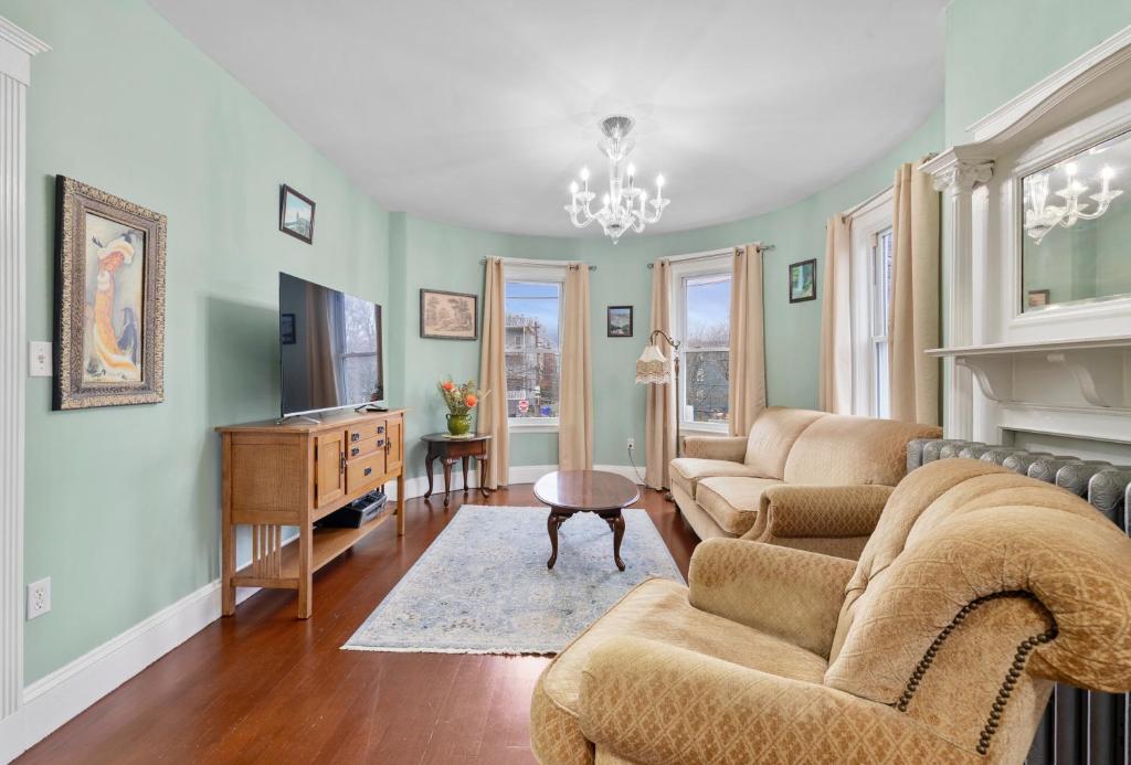 a living room with two couches and a fireplace at Bright & Spacious 2Br apartment, mins from Downtown Boston, parking in Boston