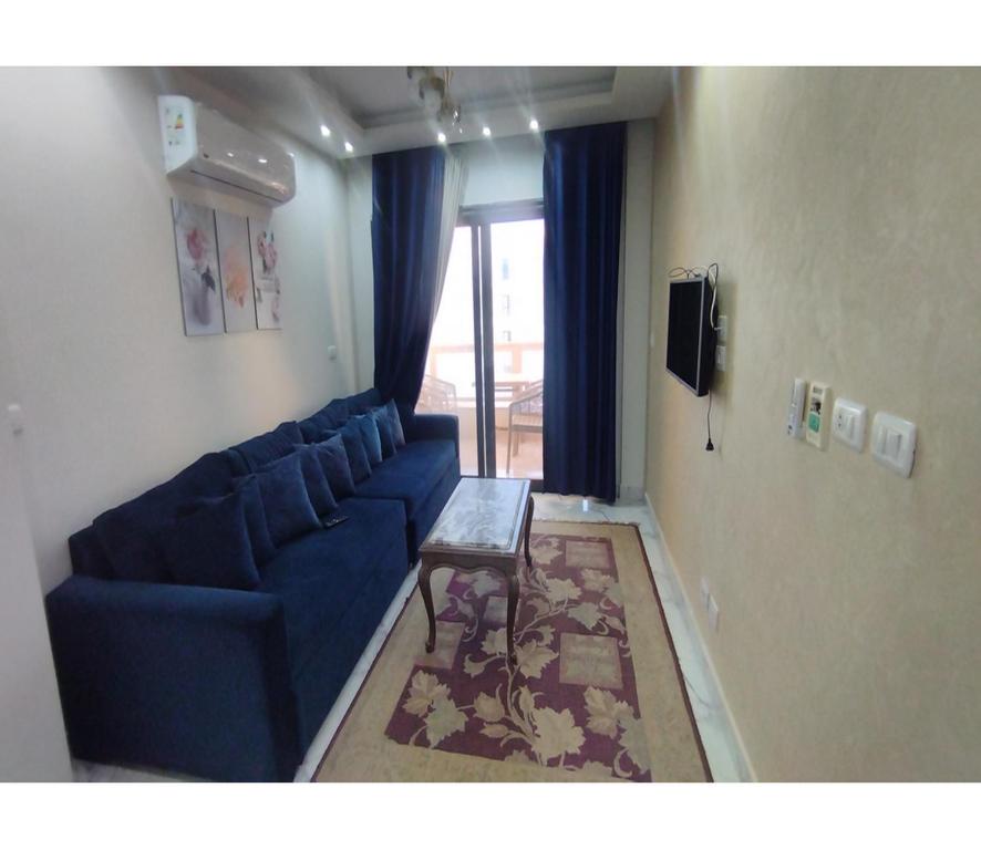 塞德港的住宿－شاليه للايجار اليومى بورتو سعيد，客厅配有蓝色的沙发和桌子