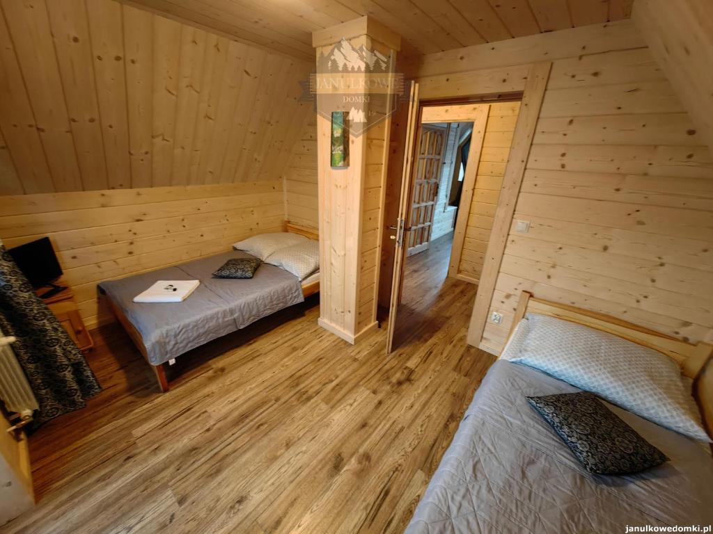a room with two beds in a log cabin at Janulkowe Domki in Zakopane
