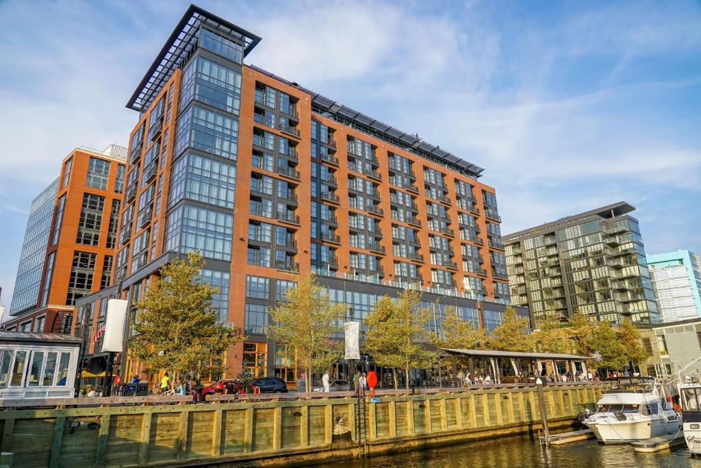 um edifício alto ao lado de um rio com um barco em InterContinental - Washington D.C. - The Wharf, an IHG Hotel em Washington