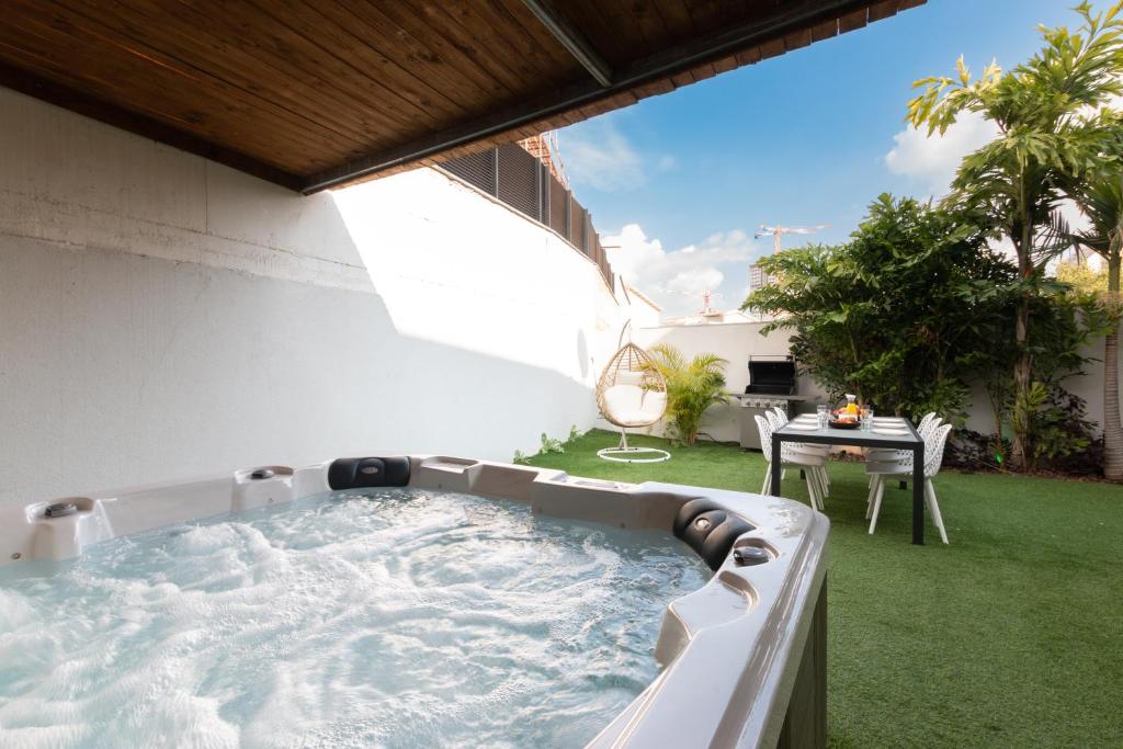 a hot tub in the backyard of a house at O&O Group - Huge Villa With Jacuzzi By The Beach in Rishon LeẔiyyon