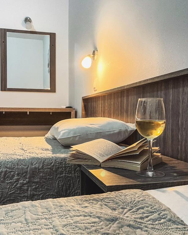 a glass of wine sitting on a table in a hotel room at Joanna Apartments in Haraki