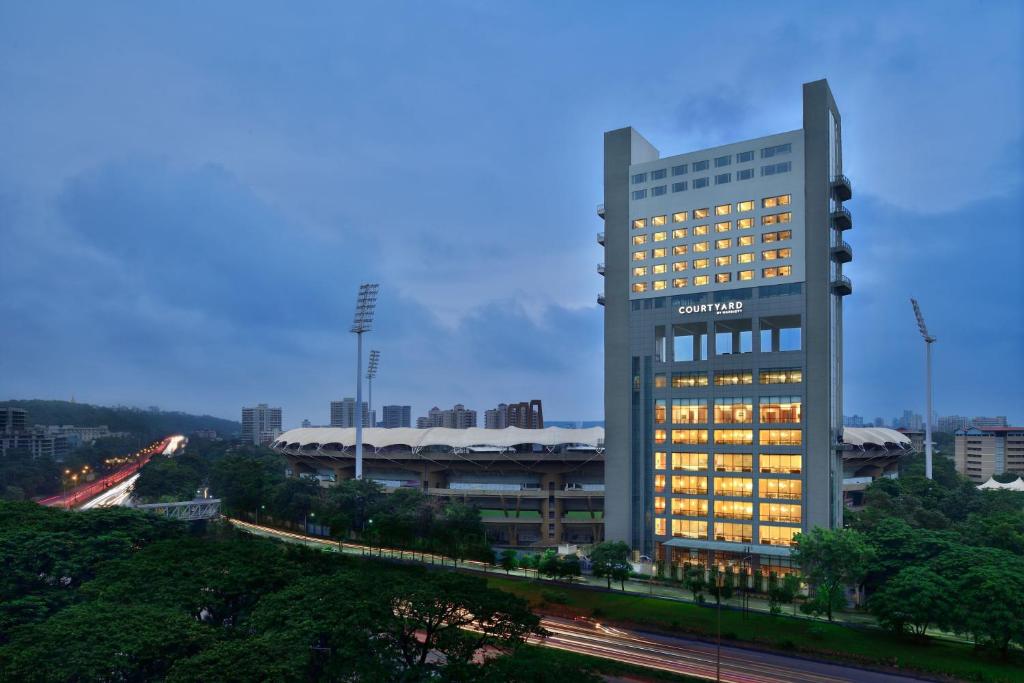 a tall building with lights on in a city at Courtyard by Marriott Navi Mumbai in Navi Mumbai