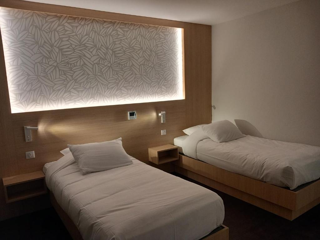 Postel nebo postele na pokoji v ubytování Hôtel Aster Restaurant Aux Arcades