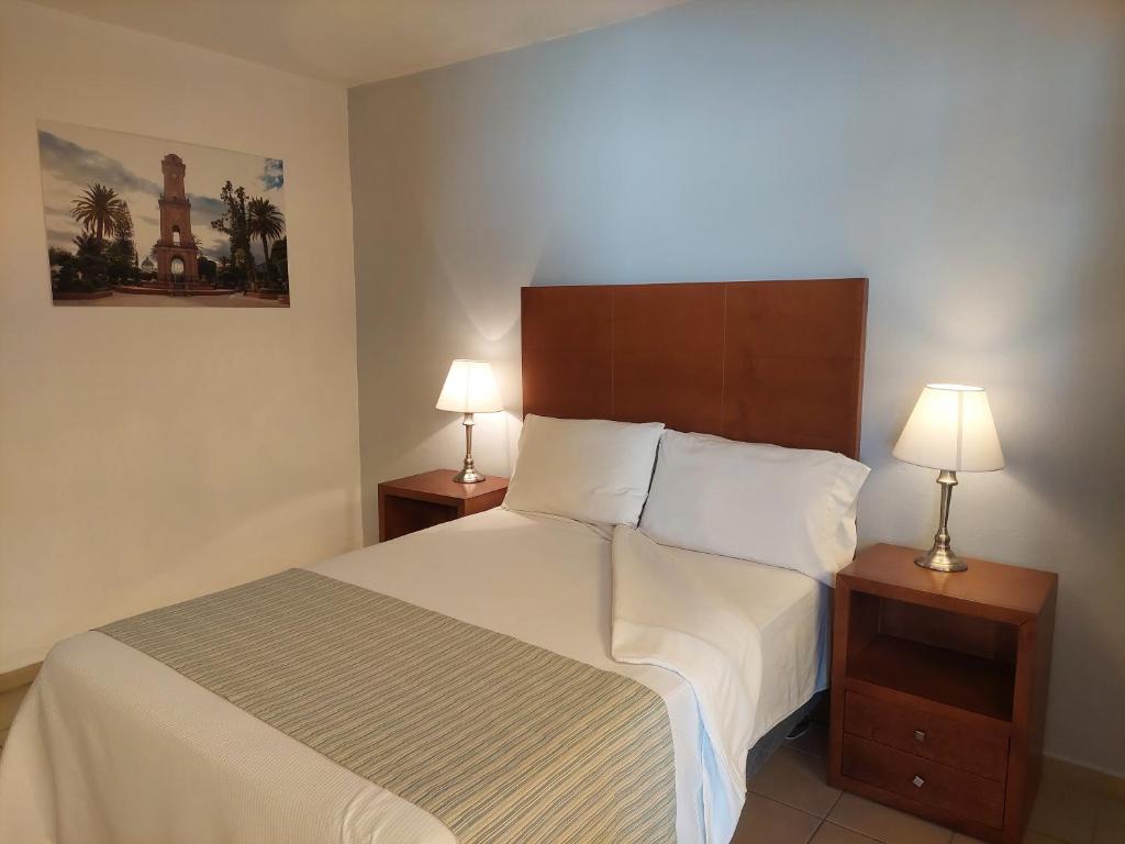パチューカ・デ・ソトにあるPosada del Ángelのベッドルーム1室(大型ベッド1台、ナイトスタンド2台付)