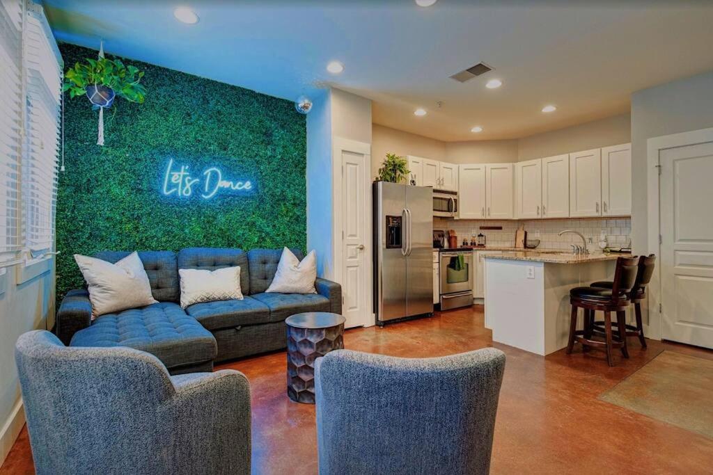 ein Wohnzimmer mit einem blauen Sofa und einer Küche in der Unterkunft Pet Friendly! Themed, Great Location! Free Pkng! in Nashville