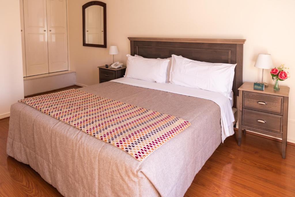 - une chambre avec un grand lit et 2 tables de chevet dans l'établissement MR Apart Providencia (ex Apart Neruda), à Santiago