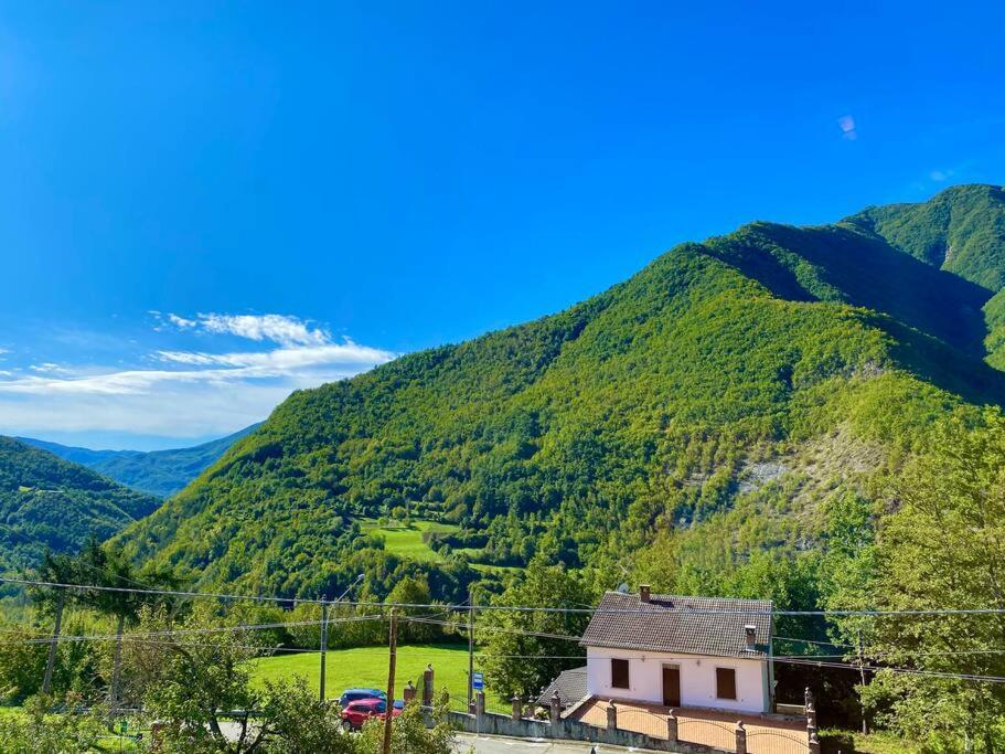a small house in front of a mountain at Villetta a schiera con giardino - Val Trebbia 