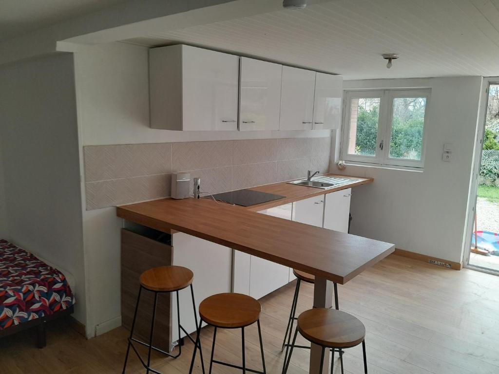 a kitchen with a counter and stools in a room at studio des Castors in Condrieu