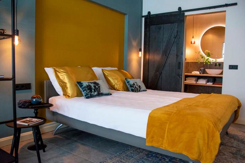 a bedroom with a large bed with a yellow blanket on it at B and B Suite No.3 in Gorinchem