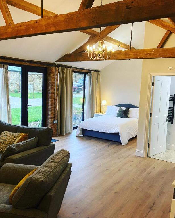 a bedroom with a bed and a couch at Tilly’s stable in Pattishall