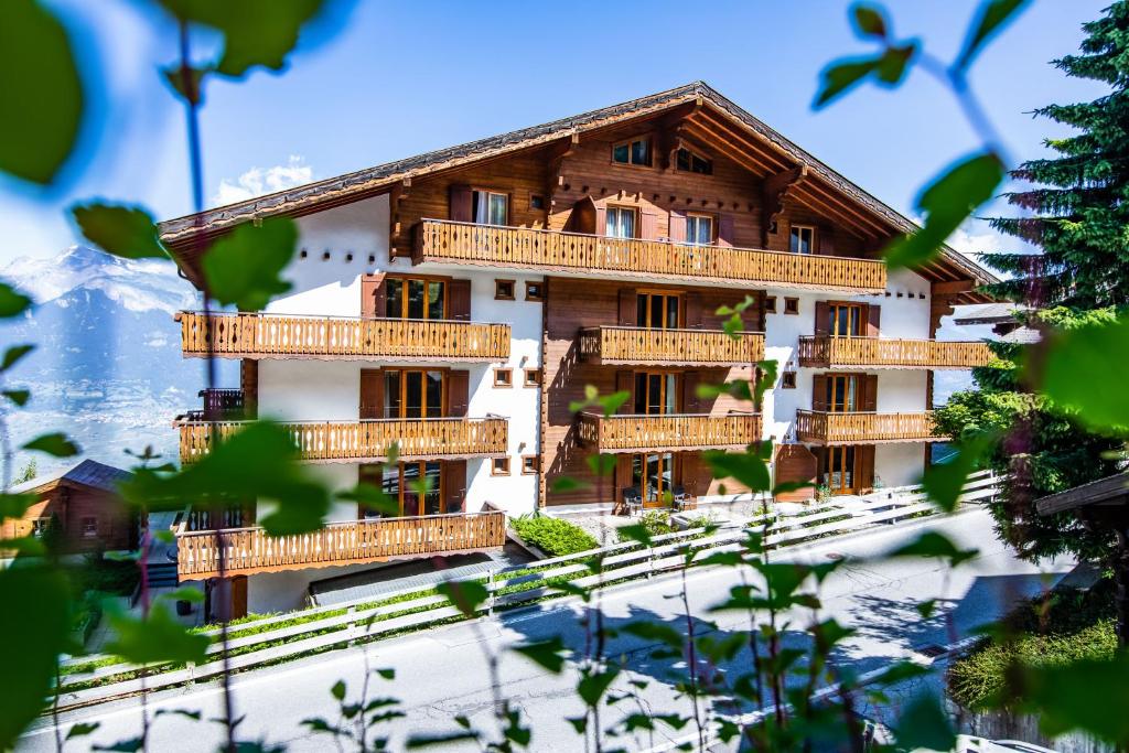 un edificio con balconi in legno in montagna di Hôtel Chalet Royal a Veysonnaz