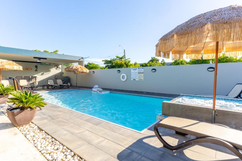 a swimming pool with a bench and an umbrella at Aquaville Dorado Moderna Villa 3 in Dorado