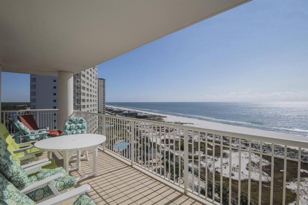 a balcony with a table and chairs and the ocean at Beach Club C1001 Amazing Corner Unit in Gulf Shores