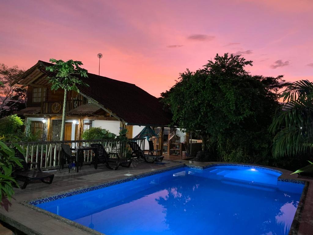 a blue swimming pool in front of a house at QUINTA VACACIONAL DIEGO ALFONSO, MY house in Macas in Macas