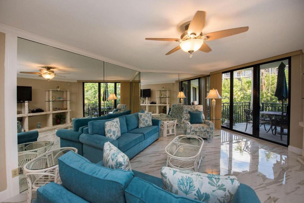 a living room with blue furniture and a ceiling fan at Paradise Found Cayo Hueso in Key West