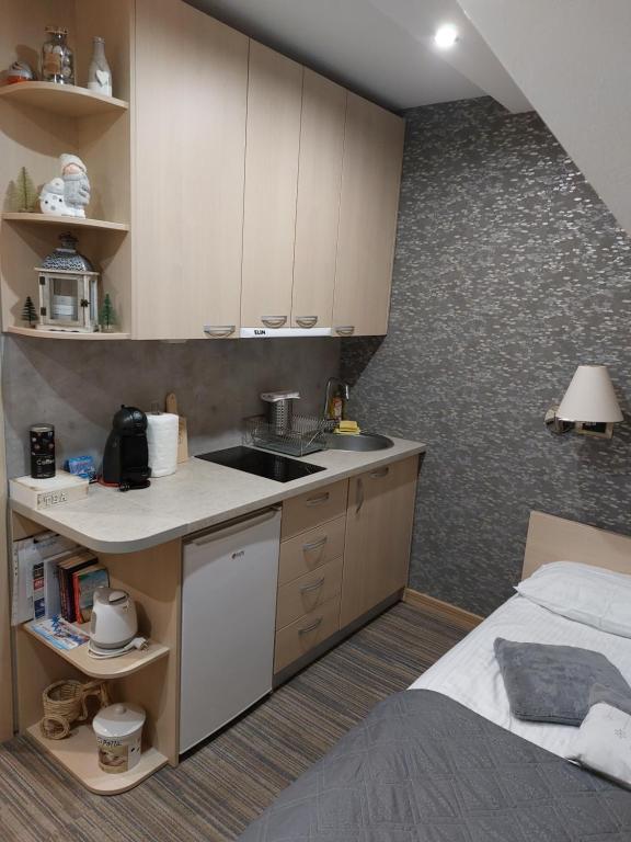 - une cuisine avec évier et un lit dans une chambre dans l'établissement Sweet Home Konaci, à Kopaonik