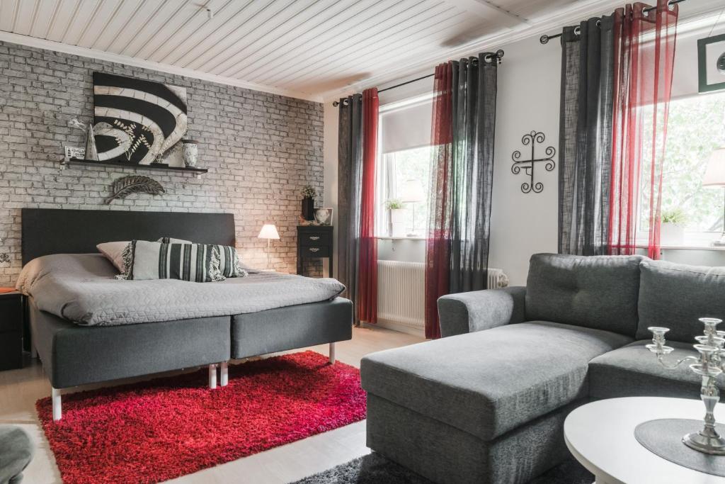 a living room with a bed and a couch at Guestly Homes - 4BR City Center Apartment in Piteå