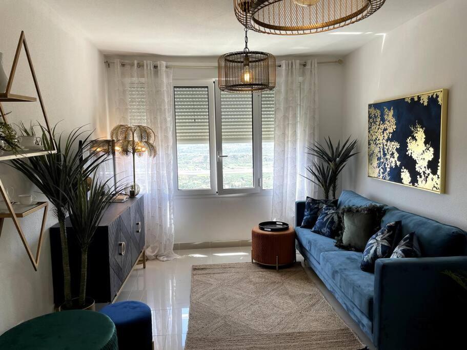 ein Wohnzimmer mit einem blauen Sofa und einem Fenster in der Unterkunft Couples Only, beautiful 1 Bedroom Apartment in Victoria Building in Mojácar