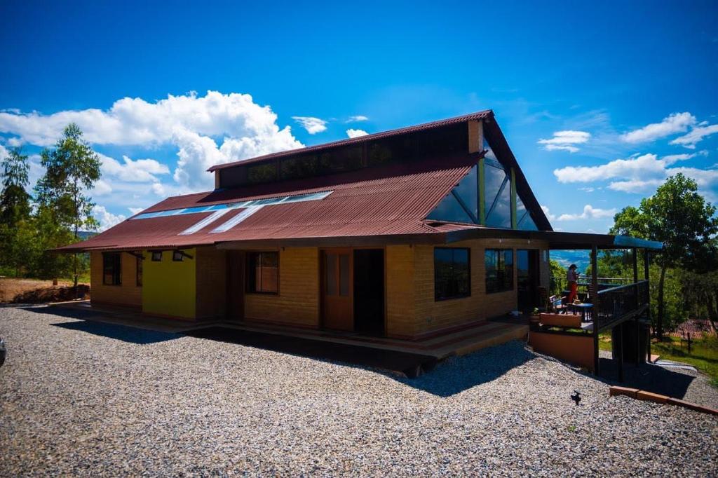 ein kleines Haus mit einem Dach auf einem Schotterplatz in der Unterkunft Casa Del Viento, Alojamiento in Villanueva