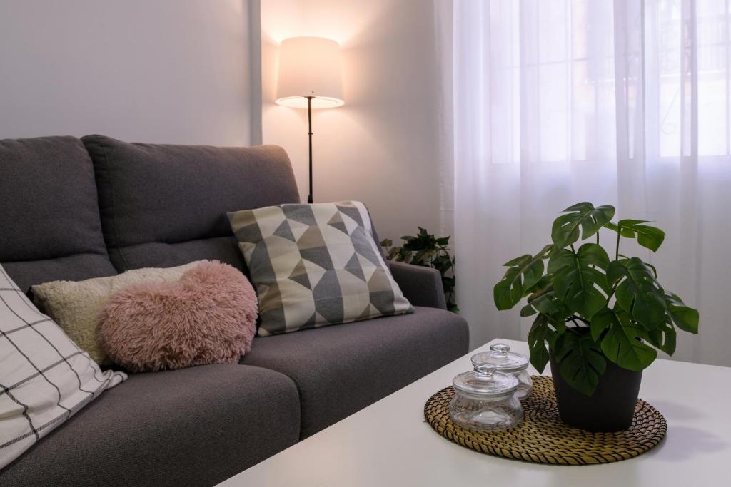 Una sala de estar con un sofá y una planta. en Estudio Playa Los Locos, Torrevieja, en Torrevieja