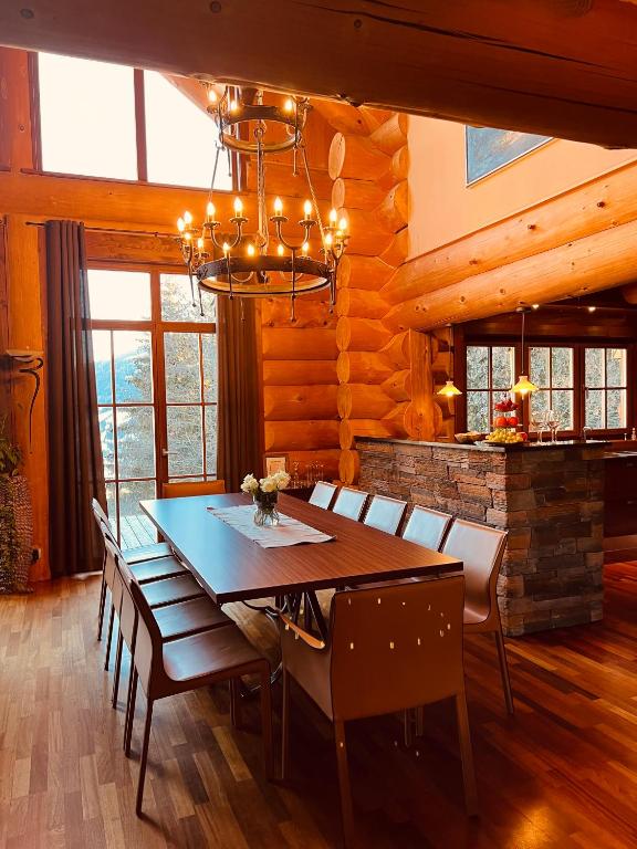 una sala da pranzo con tavolo, sedie e lampadario pendente di Chalet Caprea a Bad Kleinkirchheim