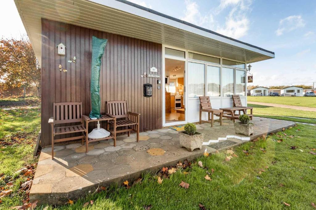 a patio with chairs and a table on a house at The Bee's Knees in Mundesley