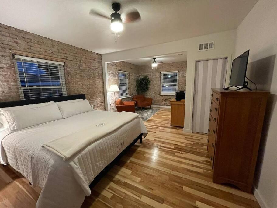 ein Schlafzimmer mit einem Bett und einer Ziegelwand in der Unterkunft Brick Street Apartment-Studio Suite in Augusta