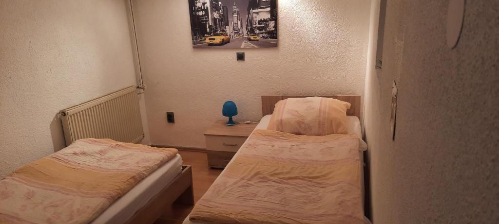 een kleine kamer met 2 bedden en een bureau bij Ostermanns Apartment in Bretten