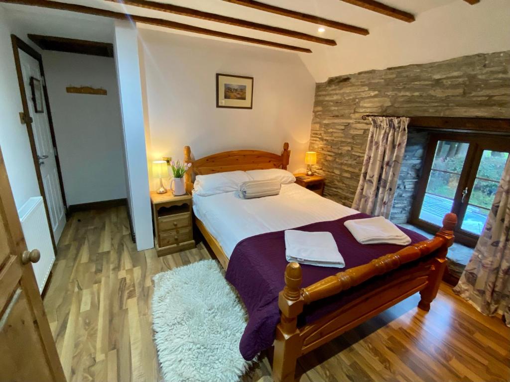 a bedroom with a bed and a stone wall at Seven Stars Inn in Builth Wells