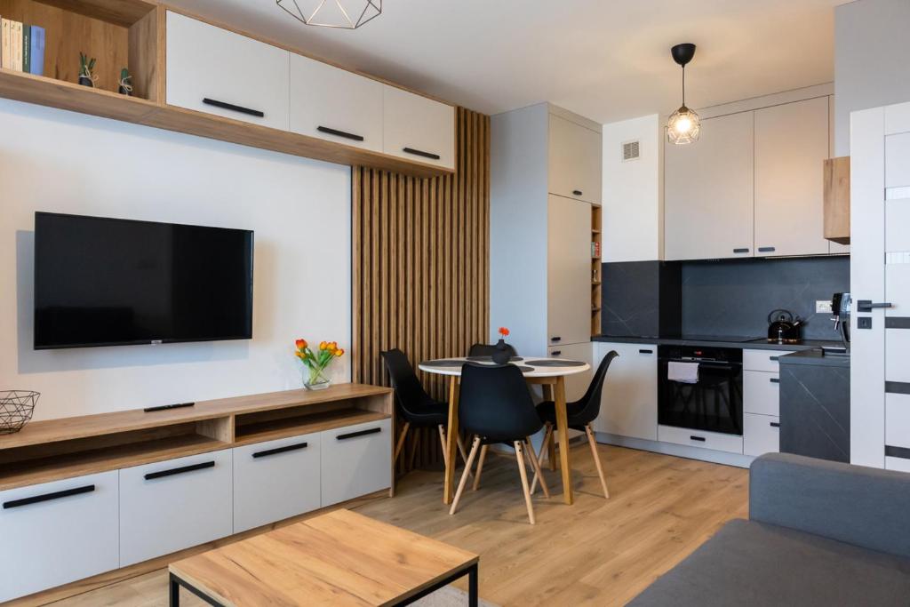 une cuisine et une salle à manger avec une table et une télévision dans l'établissement Apartament przy PILECKIEGO 34, à Biała Podlaska