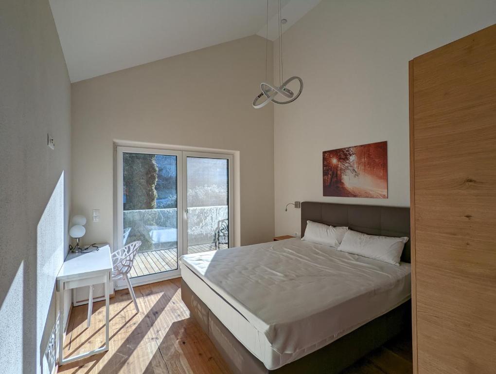 a bedroom with a bed and a desk and a window at Luxuriöse Ferienwohnung mit Sauna in Prüfingberg