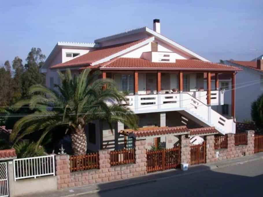 una casa con una palma di fronte di Su Suergiu a San Giovanni Suèrgiu