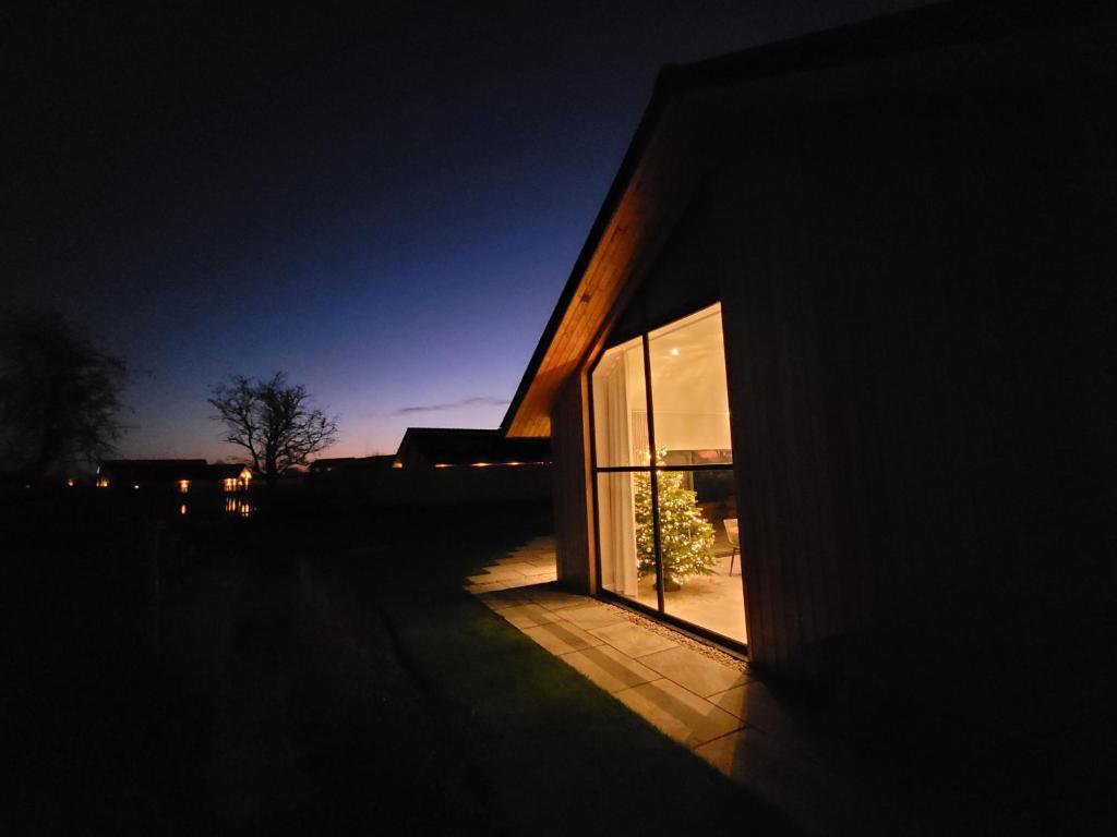 un edificio con una gran ventana en su lateral en Blue Iris Cottage, Ashlin Farm Barns en Lincoln