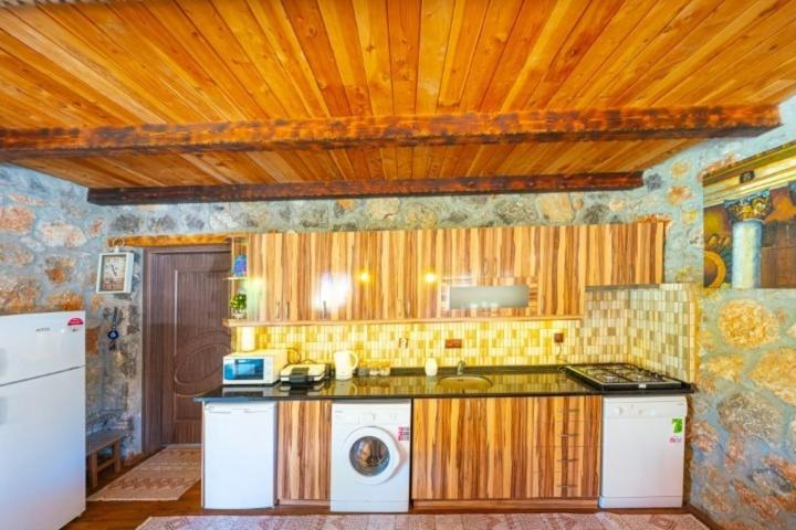 a kitchen with a sink and a washing machine at Kaya Koy Deluxe Villas Fethiye in Fethiye
