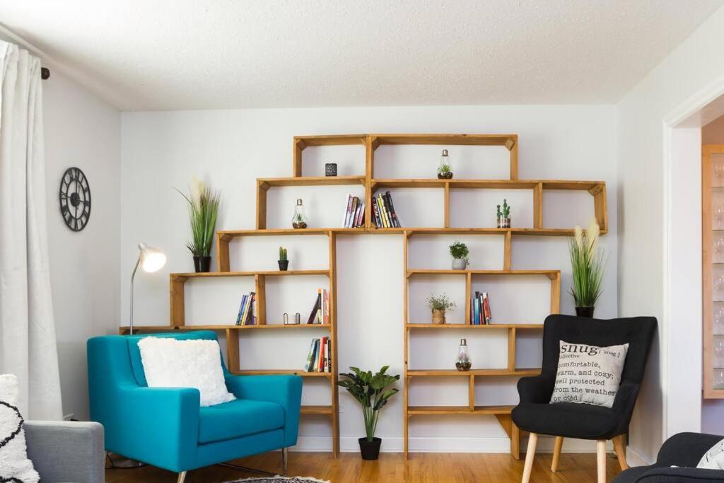 een woonkamer met een blauwe stoel en een boekenplank bij 5 Bedroom Nordic Home, Pet Friendly, Garage, WiFi, Foosball! in Edmonton