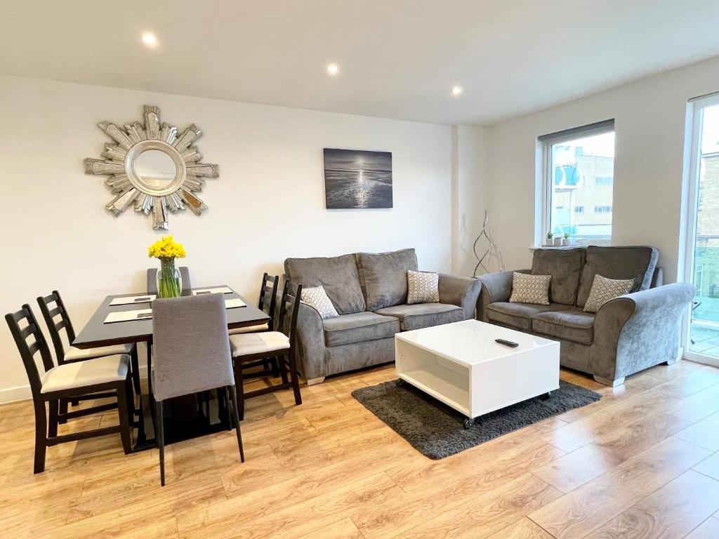 a living room with a couch and a table at Hamptons Point in Enfield