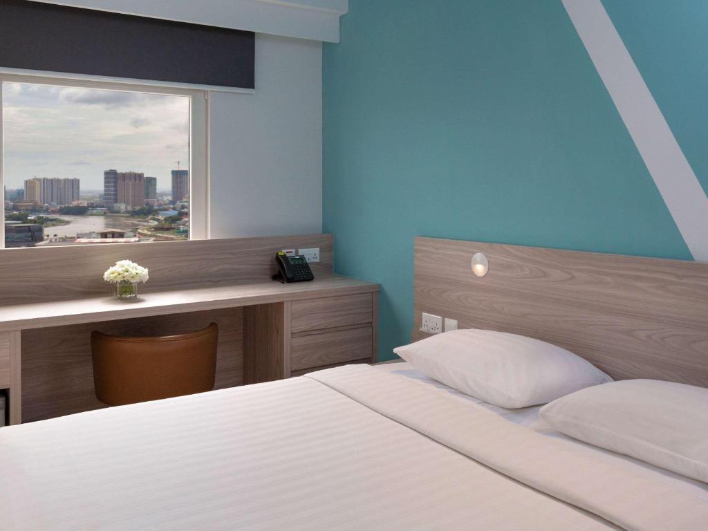 Postel nebo postele na pokoji v ubytování ibis budget Phnom Penh Riverside