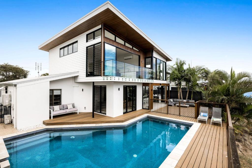 a house with a swimming pool in front of a house at 7 bedroom home on Mooloolaba canal in Mooloolaba