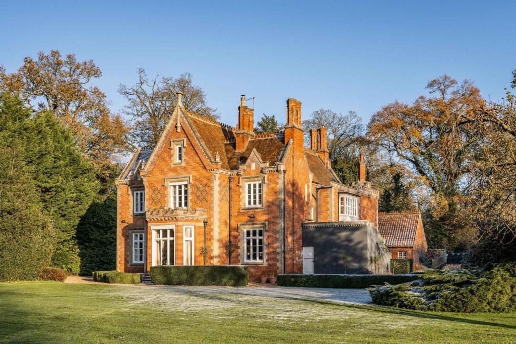 een groot rood bakstenen huis met een tuin bij Bressingham Lodge - Norfolk Holiday Properties in Diss