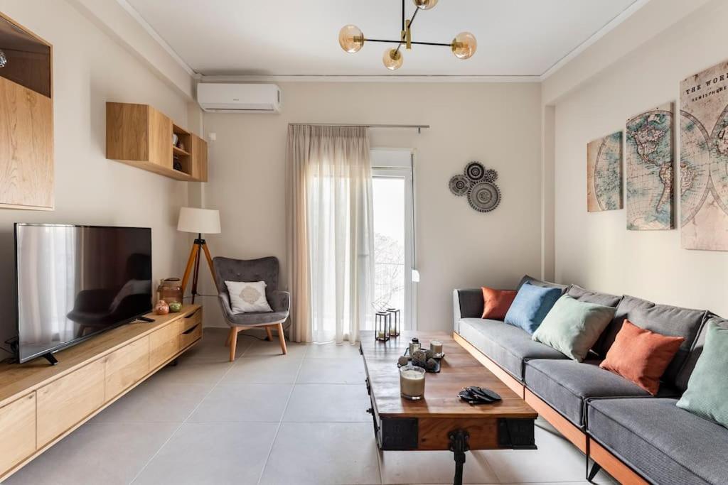 Una sala de estar con un sofá y un televisor de pantalla plana. en Acropolis View, en Atenas