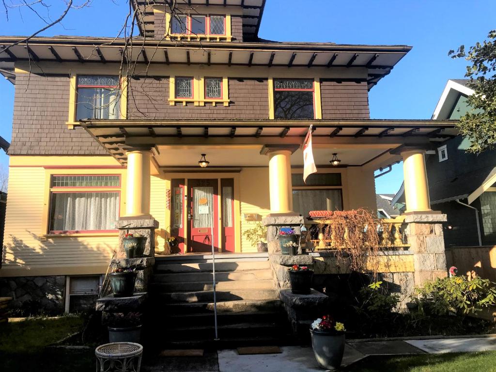 a house with a front porch with yellow columns at Windsor Guest House in Vancouver